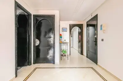 a hallway with black doors and white walls at Un super jolie appartement à gueliz in Marrakech