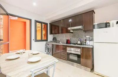 a kitchen with a table and a white refrigerator at Un super jolie appartement à gueliz in Marrakech