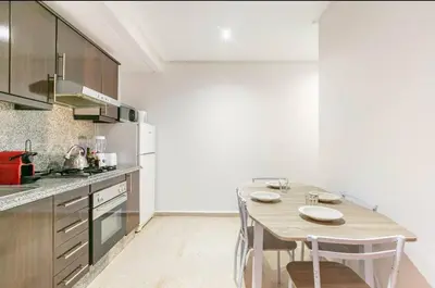 a kitchen with a table and chairs in a room at Un super jolie appartement à gueliz in Marrakech