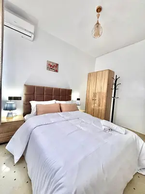 a bedroom with a large bed with white sheets at Zyarat Marrakech in Marrakech