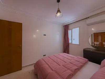 a bedroom with a pink bed and a mirror at Essalmi Luxury Apartment Gueliz in Marrakech