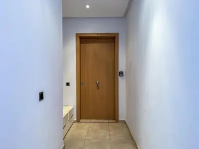 a hallway with a wooden door in a room at Prestigia 3 Bedrooms witch pool and Garden in Marrakech
