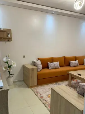 a living room with an orange couch and a table at New Apart Marrakech 2 BR-5 MN from airport in Marrakech