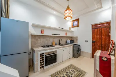 a kitchen with a white refrigerator and a stove at Riad with Rooftop Terrace in Top Medina Location, Dar El Bacha in Marrakech