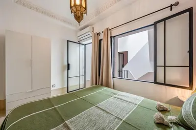 a bedroom with a large bed and large windows at Riad with Rooftop Terrace in Top Medina Location, Dar El Bacha in Marrakech