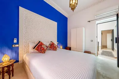 a bedroom with a white bed and blue walls at Riad with Rooftop Terrace in Top Medina Location, Dar El Bacha in Marrakech