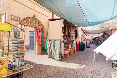a market with a bunch of clothes on a street at Riad with Rooftop Terrace in Top Medina Location, Dar El Bacha in Marrakech