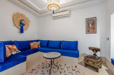 a blue couch in a living room with a table at Riad with Rooftop Terrace in Top Medina Location, Dar El Bacha in Marrakech