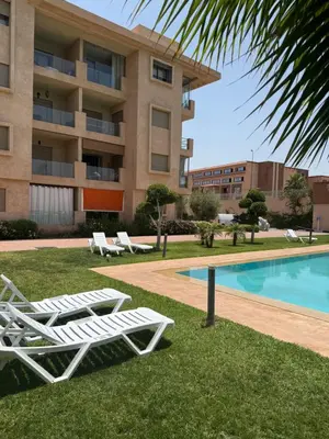 a resort with a pool and lounge chairs and a building at Marrakech in Marrakech