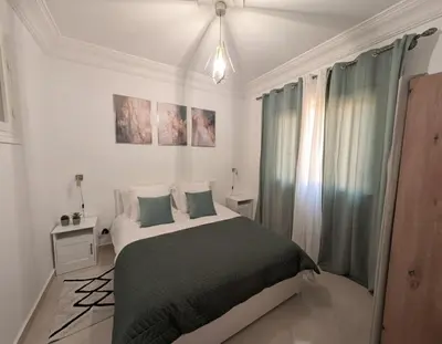 a white bedroom with a bed with green blankets and pillows at Dar'ESTRELLA calme 15min Jemaa ElFna parking free in Marrakech