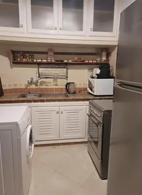 a kitchen with a refrigerator and a stove top oven at Dar'ESTRELLA calme 15min Jemaa ElFna parking free in Marrakech