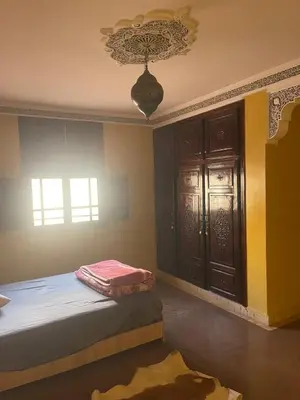 a bedroom with a bed and a window and a chandelier at Séjours villa riad pour familles in Marrakech