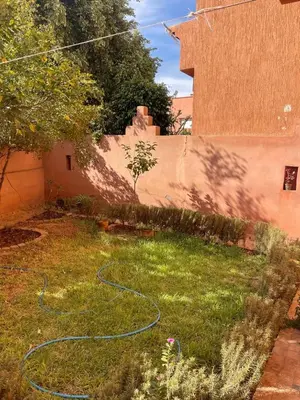 a yard with a garden hose on the grass at Séjours villa riad pour familles in Marrakech