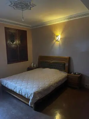a bedroom with a bed and a light on the wall at Séjours villa riad pour familles in Marrakech