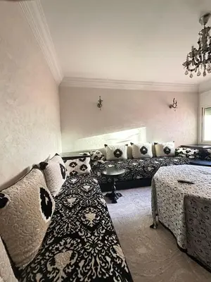 a living room with a couch and a bed with pillows at Bouchouk Apparts Gueliz in Marrakech