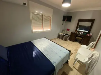 a bedroom with a bed and a chair and a mirror at Bouchouk Apparts Gueliz in Marrakech