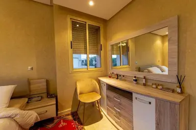 a bedroom with a bed and a mirror and a chair at Villa Sophia in Marrakech