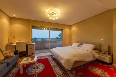 a bedroom with a bed and a couch and a window at Villa Sophia in Marrakech