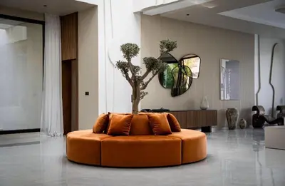 an orange couch with a tree in the middle of a room at Villa California in Marrakech