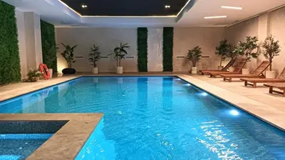 a large swimming pool with blue water in a building at New apartment - Gueliz - Pool in Marrakech