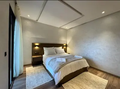 a bedroom with a large bed and a large window at New apartment - Gueliz - Pool in Marrakech