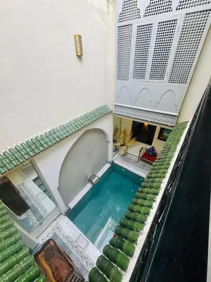 an overhead view of a swimming pool with green stairs at Riad Blue Berry in Marrakech
