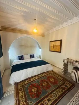 a bedroom with a bed and a rug on the floor at Riad Blue Berry in Marrakech