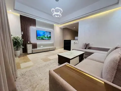 a living room with a couch and a tv at Modern & Central Apartment in Marrakech
