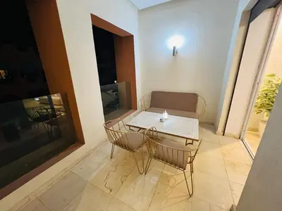 a small table and chairs in a room with a window at Modern & Central Apartment in Marrakech