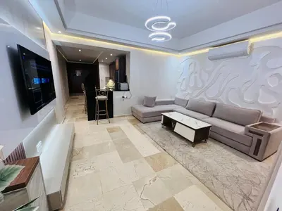 a living room with a couch and a tv at Modern & Central Apartment in Marrakech