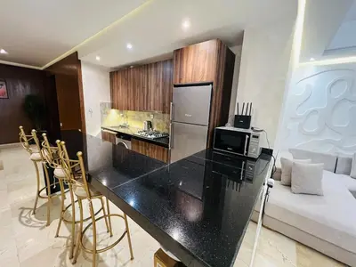 a kitchen with a counter with a microwave and a refrigerator at Modern & Central Apartment in Marrakech