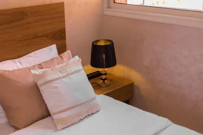 a bedroom with a bed with a lamp and a pillow at Duplex familiale au centee du Marrakech in Marrakech