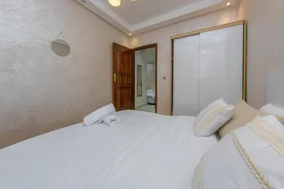 a bedroom with a large white bed with two pillows at Duplex familiale au centee du Marrakech in Marrakech
