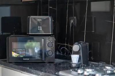 a microwave and a toaster oven on a counter at Appartement Chic M Avenue, Balcon, Piscine, Parking Wi-Fi Haut Débit Marrakech in Marrakech