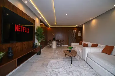 a living room with a couch and a television at Downtown Prestige 2Br apartment cinema AC in Marrakech