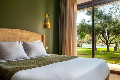 a bedroom with a bed and a large window at Appartement Luxe et Prestige, calme avec piscine in Marrakech