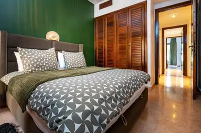 a bedroom with a bed with a green wall at Appartement Luxe et Prestige, calme avec piscine in Marrakech