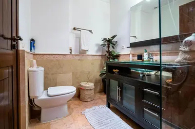 a bathroom with a toilet and a sink and a mirror at Appartement Luxe et Prestige, calme avec piscine in Marrakech