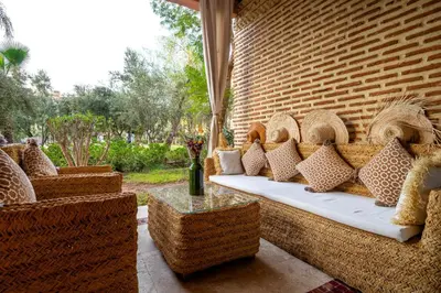 a couch with pillows sitting on a patio at Appartement Luxe et Prestige, calme avec piscine in Marrakech