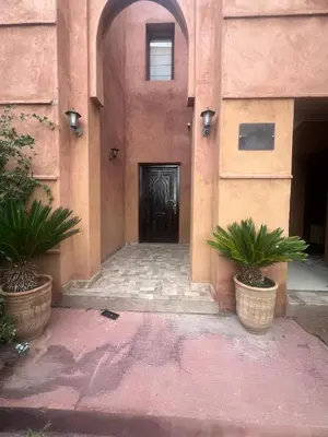 a building with two potted plants in front of a door at Marrakech Luxury Escape Full Villa Pool & Garden in Sraghna