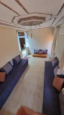 a living room with blue couches and a ceiling at Appartement Atlas in Marrakech