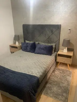 a bedroom with a large bed with blue pillows at 2 Bedroom Apartment Calm Area Parking in Marrakech