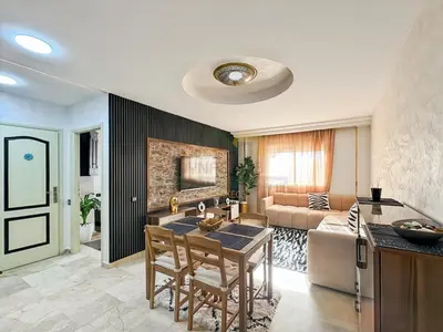 a kitchen and living room with a table and a couch at Confort Moderne au Cœur de Marrakech Proche Gare in Marrakech