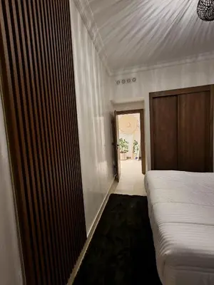 a bedroom with a bed and a door to a hallway at Marrakchi Home, Vintage Terrace Overlooking Pool in Marrakech