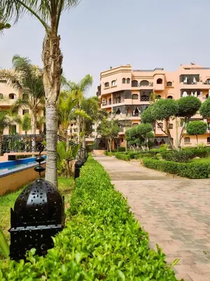a walkway in front of a building with palm trees at Marrakchi Home, Vintage Terrace Overlooking Pool in Marrakech