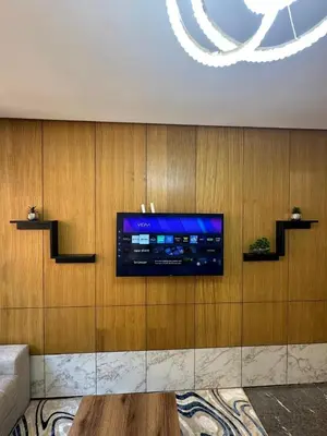 a living room with a tv on a wooden wall at City Chic New build Apartment in Marrakech