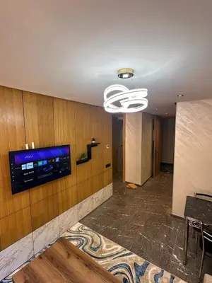 a room with a television on a wall with a table at City Chic New build Apartment in Marrakech