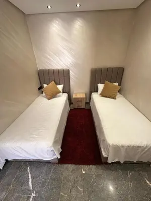 two beds in a small room with a red carpet at City Chic New build Apartment in Marrakech