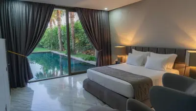 a hotel room with a bed and a swimming pool at Villa Oasis de Verre - Atlas Golf & Pool in Marrakech