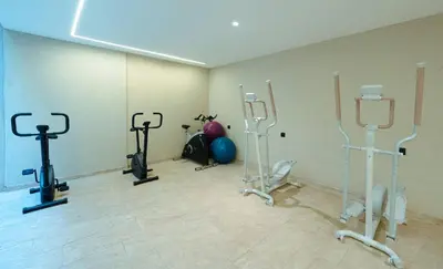 a room with several exercise bikes and a room with a gym at Le Sahara Retreat - 2 prs - Piscine - Wifi in Marrakech